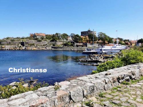 a stone wall next to a body of water with boats at Apple Blossom Studio - near Rønne and Beach in Rønne