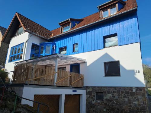 a house with a blue roof at Ferienwohnung Sophie - perfekt mit Kind und Kegel in Eitelborn