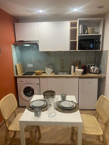 une cuisine avec une table avec deux assiettes dessus dans l'établissement Croix Rousse, à Lyon