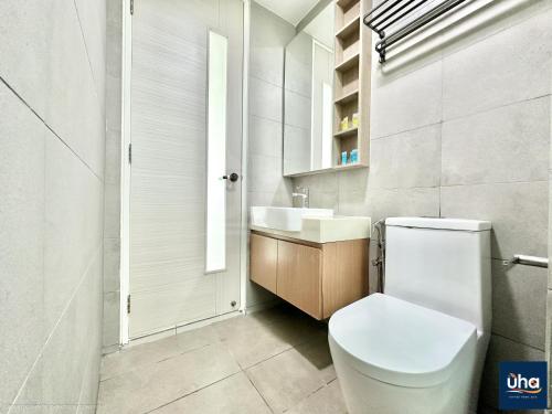 a white bathroom with a toilet and a sink at Macrolink Medini by RR JBcity in Nusajaya