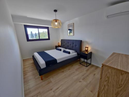 une chambre avec un lit bleu et une fenêtre dans l'établissement Le Duplex Charme des Amandiers - Air conditioning - Sea view, au Lavandou