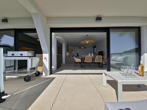 - un salon avec des portes en verre et une table dans l'établissement Le Duplex Charme des Amandiers - Air conditioning - Sea view, au Lavandou