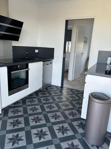 une cuisine avec un comptoir et un sol étoilé dans l'établissement villa Charlotte, à Barneville-Carteret