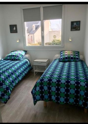 une chambre avec deux lits et une fenêtre dans l'établissement villa Charlotte, à Barneville-Carteret