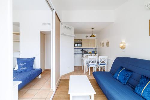 un salon avec un canapé bleu et une table dans l'établissement 902 - Apartment top floor with AC, à Menton