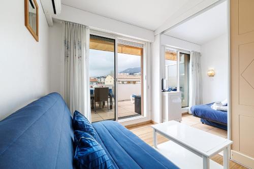 un salon avec un canapé bleu et une table dans l'établissement 902 - Apartment top floor with AC, à Menton