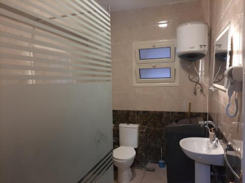 un baño con inodoro y lavabo en Moon homes - Downtown Cairo, en El Cairo