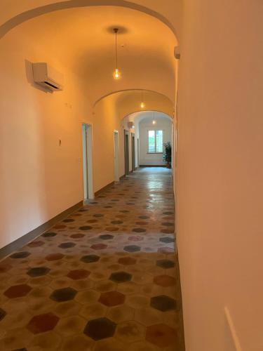 an empty hallway with a tile floor and an archway at Il Genio - Residenza D'Epoca in Pisa