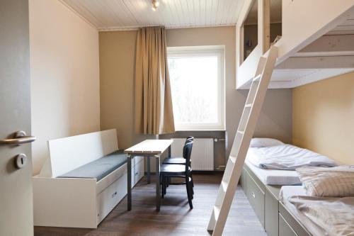 Dormitorio con scrivania e letti a castello. di Haus Waldläufer a Braunlage