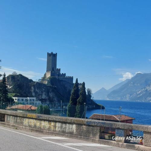 a castle on top of a hill next to the water at NATALI Appartamens Rosa in Malcesine