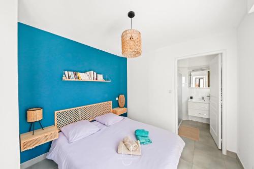 a bedroom with a blue accent wall and a bed at Maisonnette Saona vue mer plages 800m WiFi CLiM PK By HC in Carqueiranne