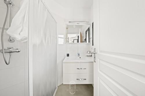 a white bathroom with a sink and a mirror at Maisonnette Saona vue mer plages 800m WiFi CLiM PK By HC in Carqueiranne