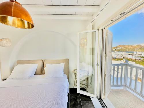 ein Schlafzimmer mit einem Bett und einem Balkon in der Unterkunft Grace Villa Mykonos in Mykonos Stadt