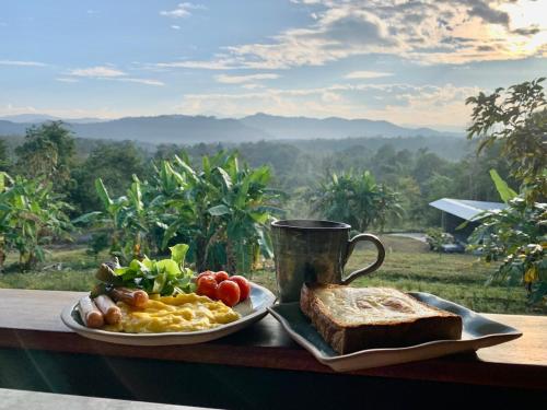 ein Teller mit Essen, Toast und einer Tasse Kaffee in der Unterkunft Tiny House on the Hill Farmstay in Ban Kat Khi Lek