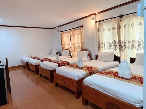 a group of four beds in a room at Vangvieng Sisavang Mountain View Hotel in Vang Vieng