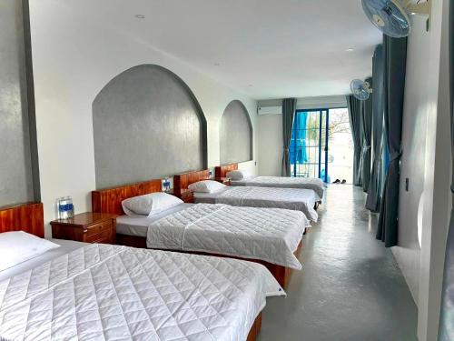 a group of three beds in a room at KParis Beach Resort in Bình Sơn