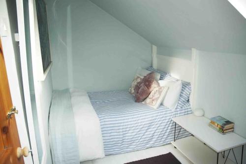 a small room with a bed with two pillows on it at Cosy Seaside Cottage Baltimore in Ballylinchy