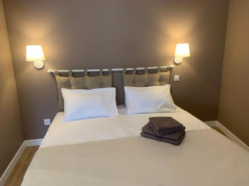 a bed with two pillows and two towels on it at MAISON D' HÔTES L'Écurie de Luzerand in Menglon