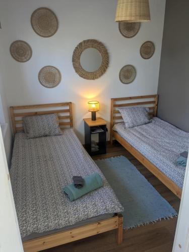 two beds in a room with a lamp on a table at Peedu saunamaja in Hiiumaa