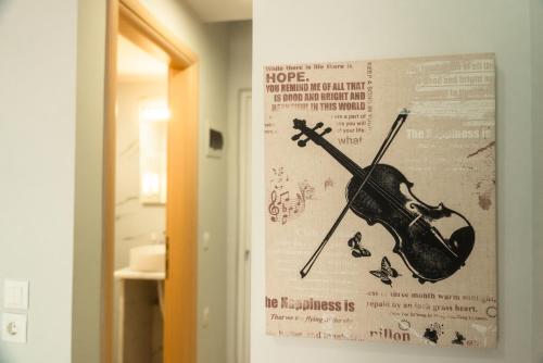 a poster of a violin hanging on a wall at Aktis Sea View Studios in Perea