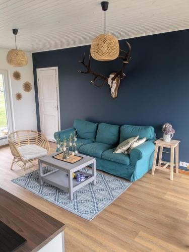 a living room with a blue couch and a table at Peedu saunamaja in Hiiumaa