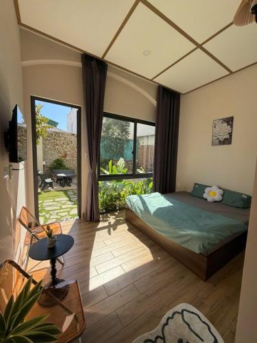 a bedroom with a bed and a large window at K'TY Homestay Phan Thiết in Ấp Bình Hưng