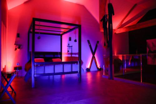 a bedroom with a bed in a room with red lights at 7eme loft in Saint-Victor-de-Cessieu