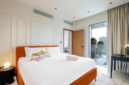 a bedroom with a white bed and a large window at 1BR Gem with Stunning Marina Views, Close to Metro in Dubai
