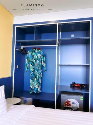 a bedroom with a bed and a blue wall at Flamingo Hai Tien in Hoằng Hóa