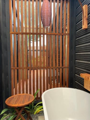 a wooden fence with a table and a vase at Hamurana Roost in Rotorua