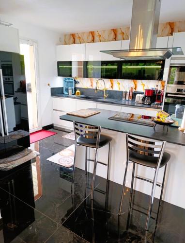 a kitchen with a counter and two bar stools at Superbe Villa 5 étoiles Presqu'Île de Giens la Madrague Rita la Villa d'Or vue mer piscine in Hyères