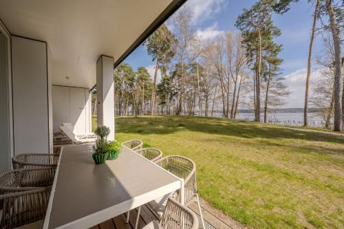 a patio with a table and chairs and a view of a field at Marina Maisonette Seeblick mit Pool und Sauna in Bad Saarow