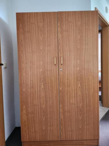 a wooden cabinet with two doors in a room at Das Meyman in Kölleda