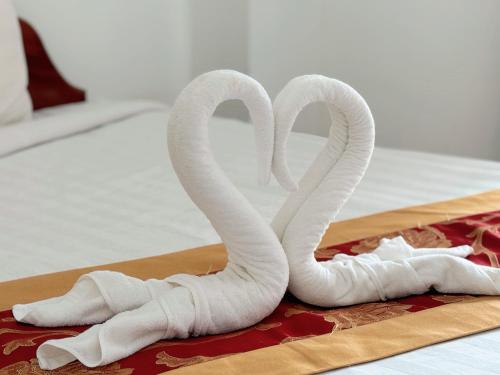 two white towel swans sitting on a bed at Vangvieng Sisavang Mountain View Hotel in Vang Vieng