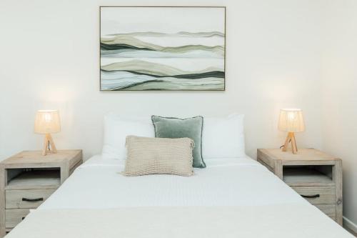 ein Schlafzimmer mit einem weißen Bett mit zwei Lampen in der Unterkunft Marcoola Sands 6 - Pool to Beach in Marcoola