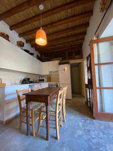 a kitchen with a wooden table and chairs and a refrigerator at Spiti Calliope in Kathikas