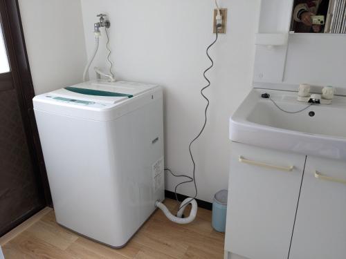 a washing machine in a bathroom with a sink at Guest house AIZU First in Aizuwakamatsu