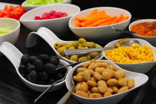 a table topped with bowls of different types of vegetables at Hotel - Teranea City Hvar in Hvar