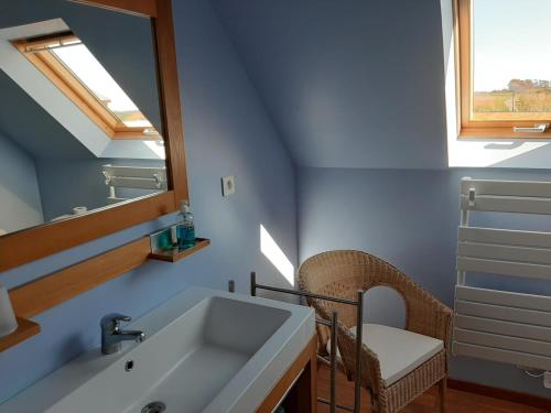 une salle de bain avec un lavabo et un miroir dans l'établissement Maison de vacances, à Tréguennec