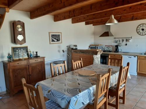 une cuisine et une salle à manger avec une table et des chaises dans l'établissement Maison de vacances, à Tréguennec