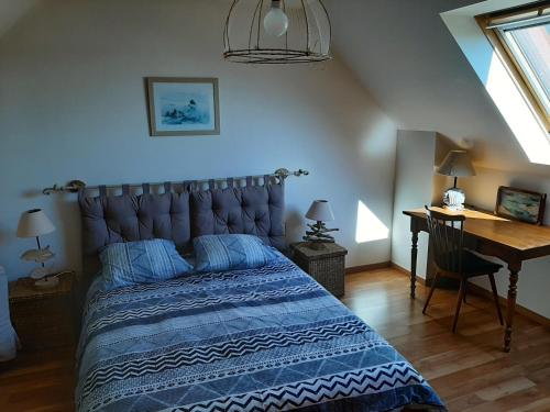 - une chambre avec un lit bleu et un bureau dans l'établissement Maison de vacances, à Tréguennec