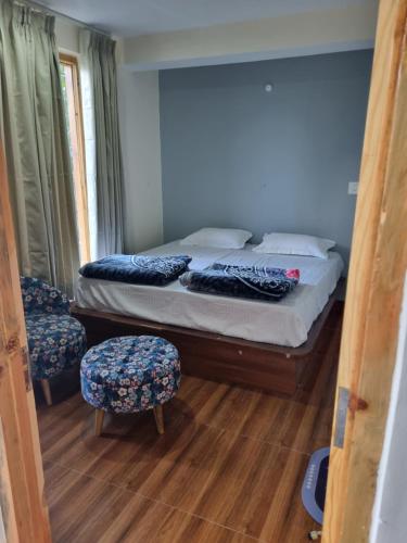 a bedroom with a bed and two chairs in it at Sukoon Retreat Guesthouse in Tosh