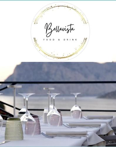 a table with white plates and wine glasses on it at SAN TEODORO PUNTA EST SPETTACOLARE QUADRILOCALE VISTA MARE in Capo Coda Cavallo