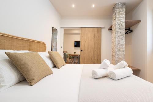 a bedroom with a large white bed with towels on it at Lisboa by Concept Flats in Valencia