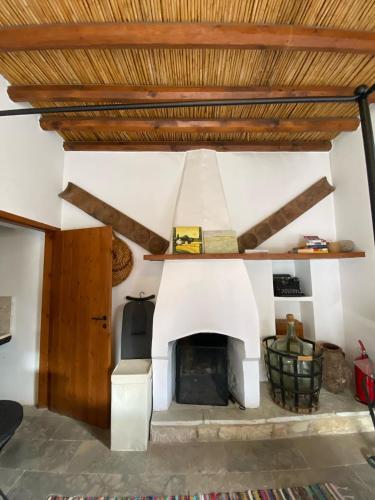 a fireplace in a living room with a wooden ceiling at Spiti Calliope in Kathikas