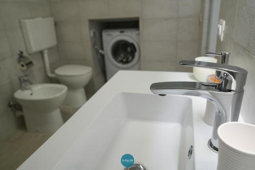 a bathroom with a sink and a washing machine at La Dolce Vita - Casa Vacanze in Laterza