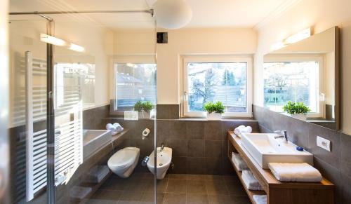 a bathroom with a sink and a toilet and a tub at Parc Hotel Florian in Siusi