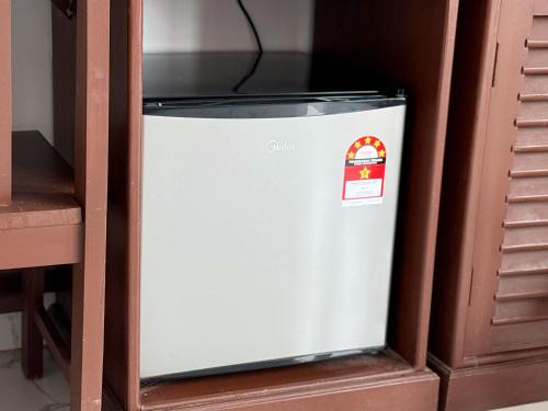 a refrigerator in a cabinet with a sticker on it at Vangvieng Sisavang Mountain View Hotel in Vang Vieng