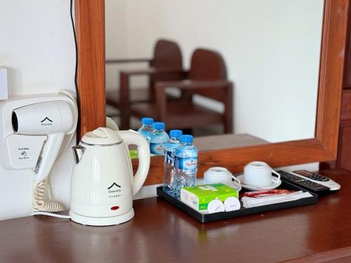 a counter with a coffee maker and water bottles on it at Vangvieng Sisavang Mountain View Hotel in Vang Vieng
