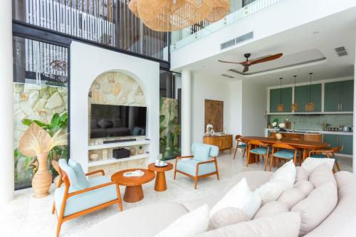 a living room with a couch and a dining room at Villa Oria Canggu - Brand new 3BR mediterranean Villa with Ricefield sunset view in Kerobokan